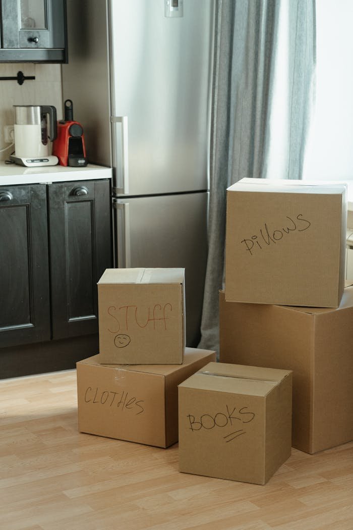 services-03 Cardboard boxes labeled with contents in a kitchen, suggesting a recent move-in.
